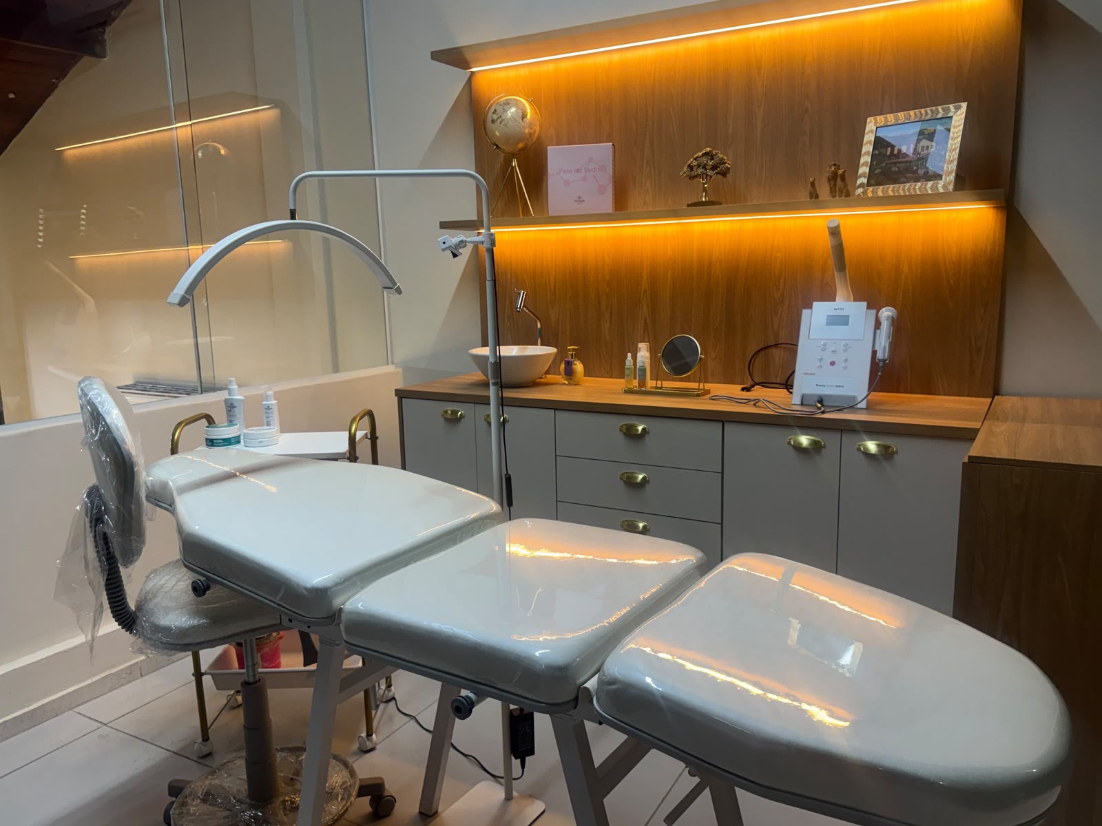 Cabine VIP no mezanino da Áurea, em Resende, com maca, luminária de LED e bancada de atendimento